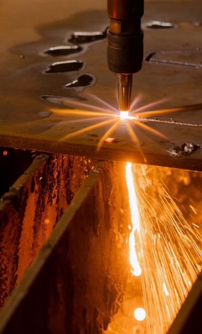 Процесс газо-пламенной резки толстого листового металла с характерным пламенем и искрами