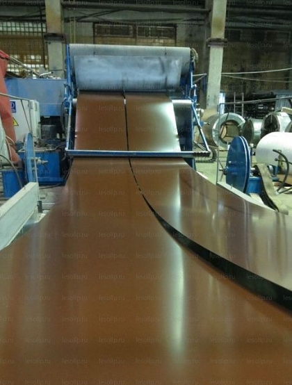 Процесс размотки рулонного металла на производственной линии