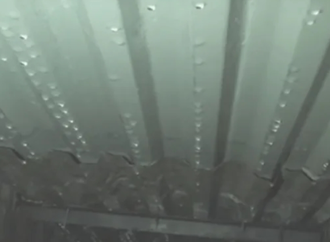 Капли конденсата на внутренней стороне профнастила кровли навеса в зимний период