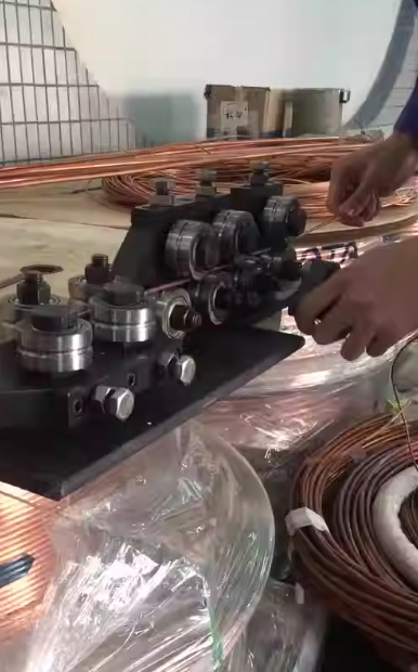 Процесс рихтовки проволоки на специальном оборудовании с роликами