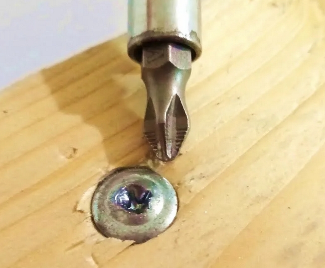 Инструменты: шуруповерт с битой Philips и поврежденная головка самореза с сорванным шлицем