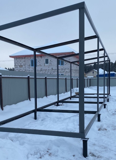 каркас временного здания из швеллеров зимой, рама с обвязкой и стойками под снегом, надежная основа для работ