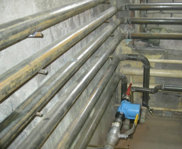  отопительные металлические трубы внутри дома с аккуратной теплоизоляцией и креплениями, пример надежной зимней разводки