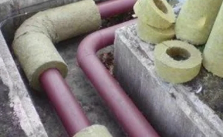 участок зимнего водоснабжения с металлическими трубами и утеплением, аккуратные крепления в подсобном помещении без конденсата