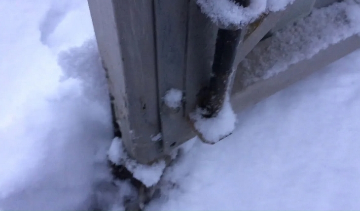 Наледь и снег в направляющей балке откатных ворот