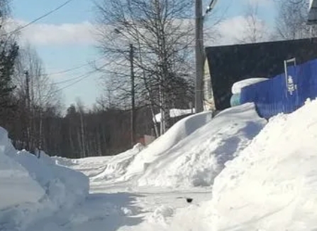 Забор из профнастила зимой, удерживающий сугроб снега